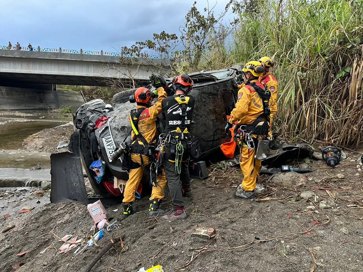 轎車翻落橋下嚴重毀損，警消救出受困駕駛。 圖：消防局提供