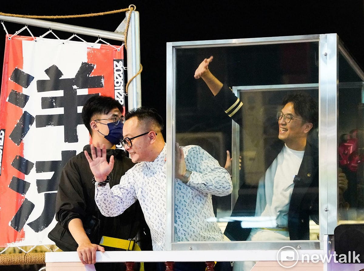 民進黨台北市長侯選人沈伯洋赴基隆與市長侯選人童子瑋合體「洋流童行」。兩人在防彈玻璃後與支持者致意。  圖：張良一／攝