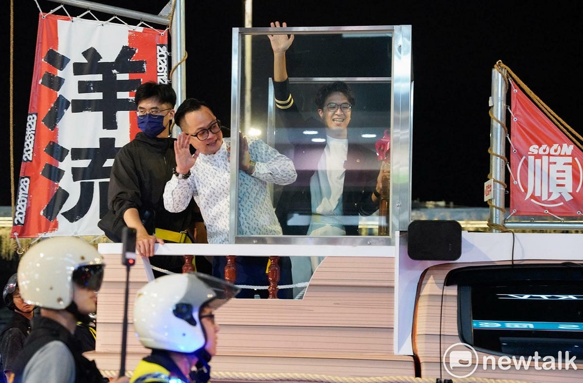民進黨台北市長侯選人沈伯洋赴基隆與市長侯選人童子瑋合體「洋流童行」。兩人在防彈玻璃後與支持者致意。  圖：記者張良一攝