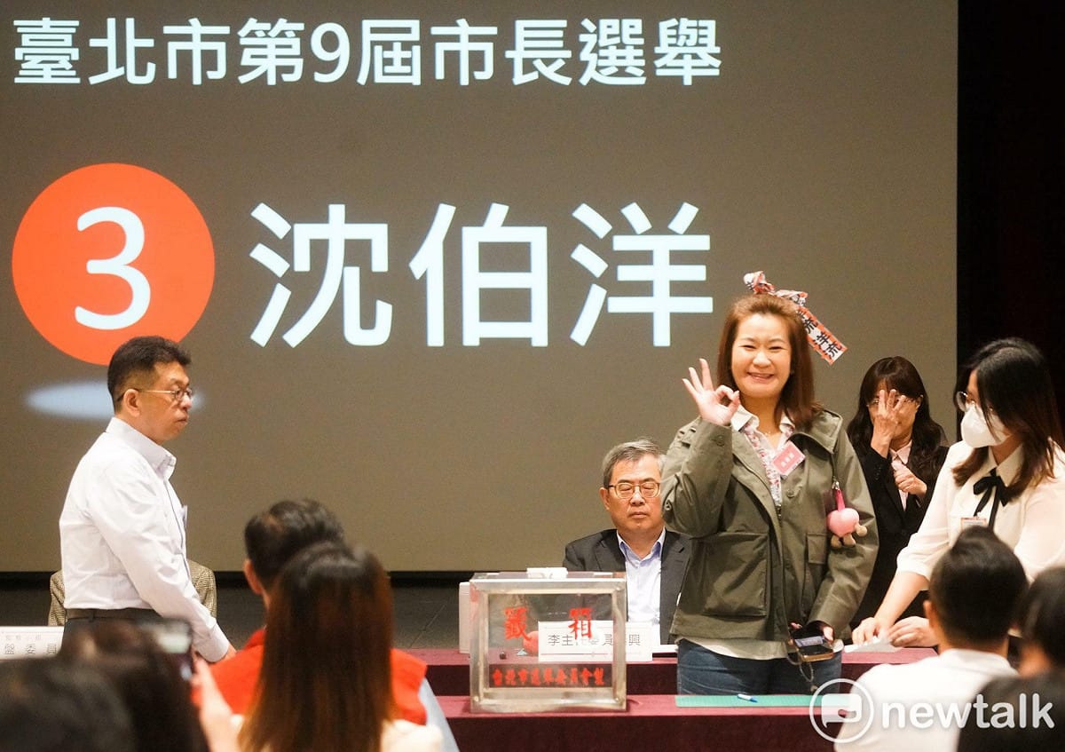 民進黨台北市長候選人沈伯洋邀請市民Lydia林小姐代為抽籤，今天Lydia也特別在頭髮上綁著「洋流」飄帶現身，並抽到3號。 圖：張良一 / 攝