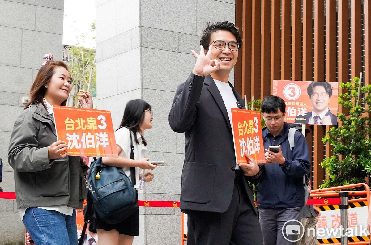民進黨台北市長候選人沈伯洋由市民Lydia代抽出3號，兩人也在外比出3之手勢，並拿出「台北靠3」牌子。 圖：張良一 / 攝