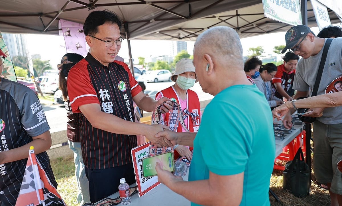 林智鴻(左)在「台北市長候選人電視辯論」直播時，在龍成宮發放限量「洋流」飄帶、貼紙與手搖旗。 圖：林智鴻競總／提供（資料照）