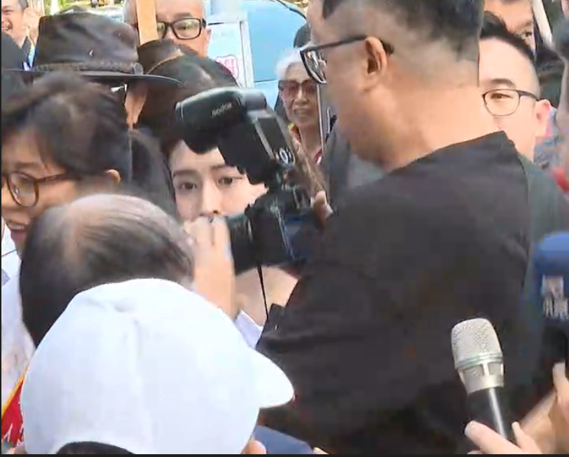 蔣萬安競辦攝影師（黑色衣服）架拐子撞女記者。 圖：讀者 / 提供