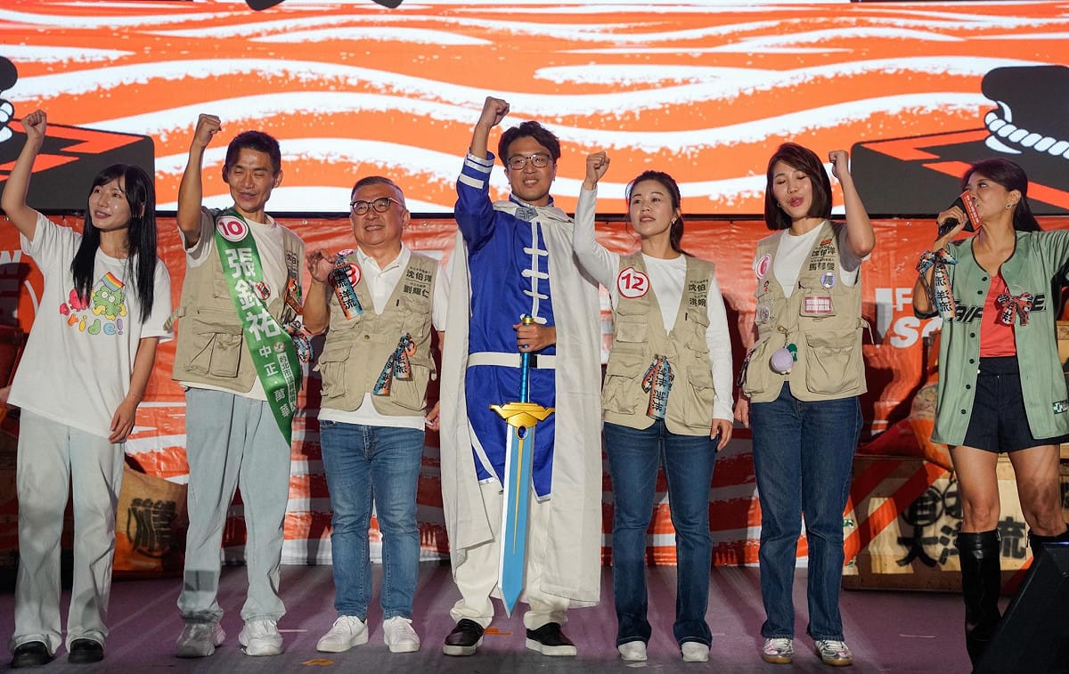 沈伯洋晚間抵達龍山寺前艋舺公園，與民進黨議員及議員候選人同台，向現場支持者揮手致意。 圖：張良一／攝