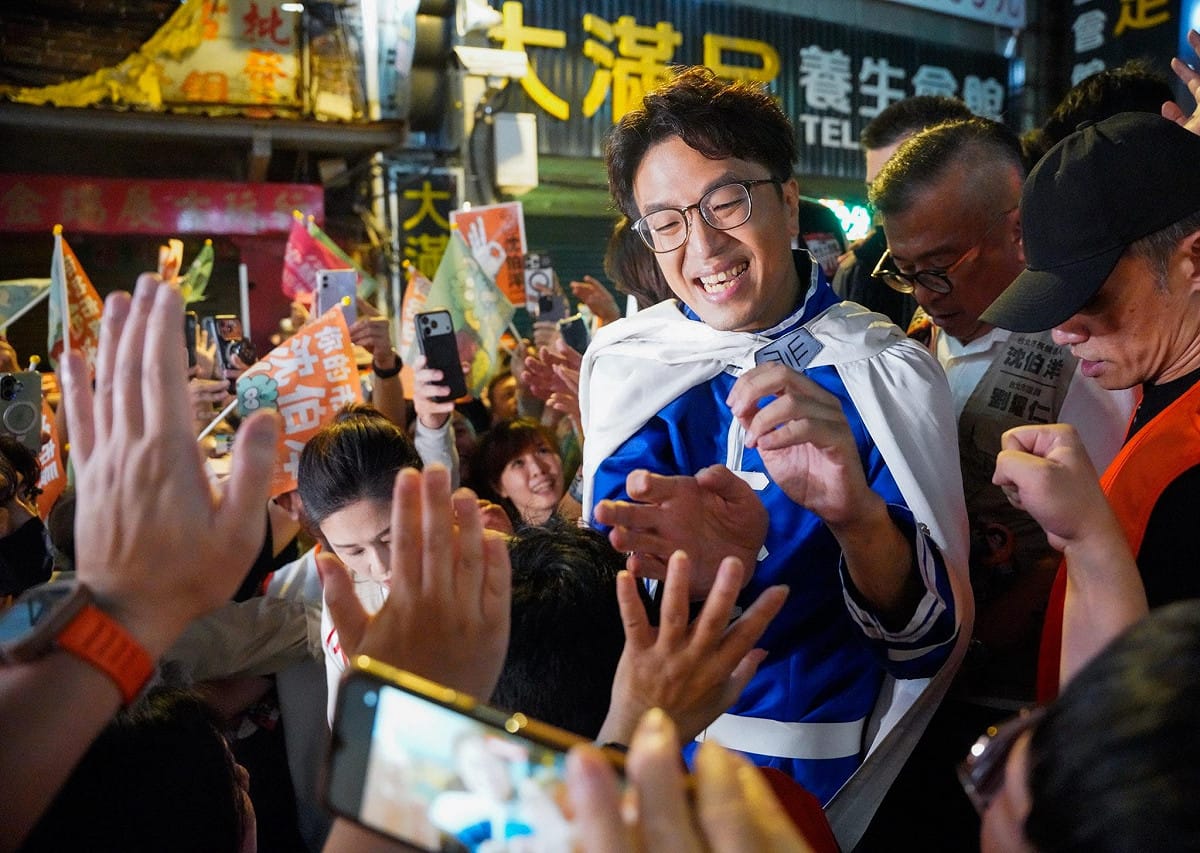 沈伯洋身穿藍色競選服裝，面帶笑容與現場支持者近距離互動，民眾紛紛伸手迎接。 圖：張良一／攝