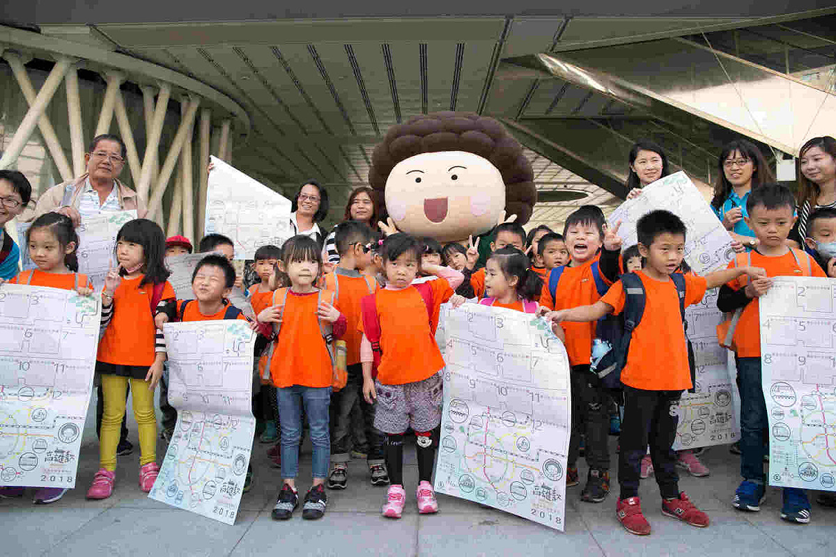 花媽人偶帶著高雄市2018特色年曆，在總圖前快閃發放。 圖：高雄市政府/提供