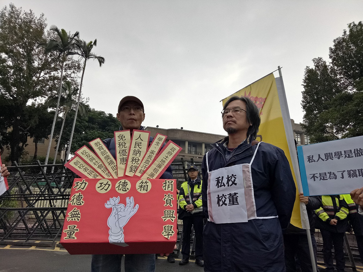 高教工會今（8）天手持自製的「功德箱」到行政院門前抗議，痛批政院版的私校轉退條例「根本是在打假球」。 圖：高教工會提供