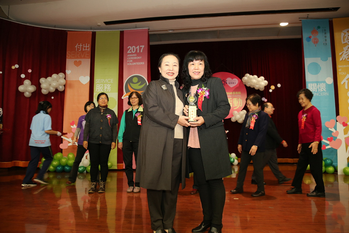 縣長張花冠致贈獎盃給服務時數高達6,320小時的薛惠伎。 圖：嘉義縣政府/提供