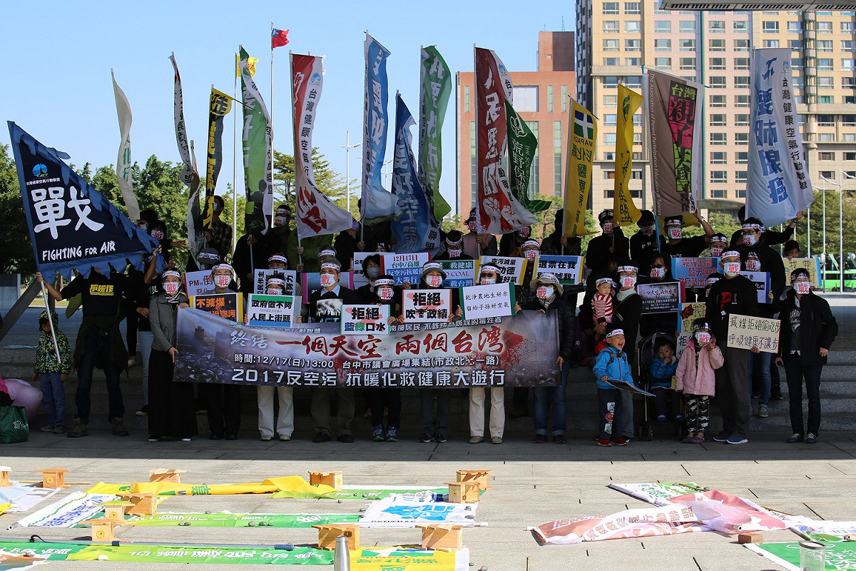 中部15個NGO團體今(11)日舉行「霧霾圍城 公民圍府」行動第六天，並並以團體旗幟排出大大的「戰」字，宣示「為空氣而戰」，號召全民12月17日上街為爭取呼吸權站出來參加反空污抗暖化大遊行，也呼籲政府在空污治理政策上不要再吹牛皮，要實際具體空污減量，而非只會透過包裝話術唬弄市民。 圖：張美惠/攝影提供