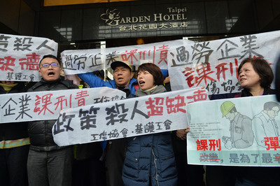 行政院長賴清德12日與工商團體領袖舉行「中華民國工
商協進會工商早餐會」，工運團體在會場門口高舉布條
、喊著口號表達對勞基法修法的立場。 圖：中央社