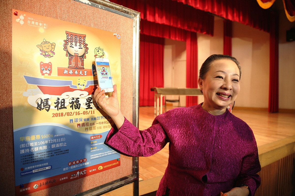 張花冠用手機掃瞄「媽祖福星號」的QRCODE。 圖：嘉義縣政府／提供