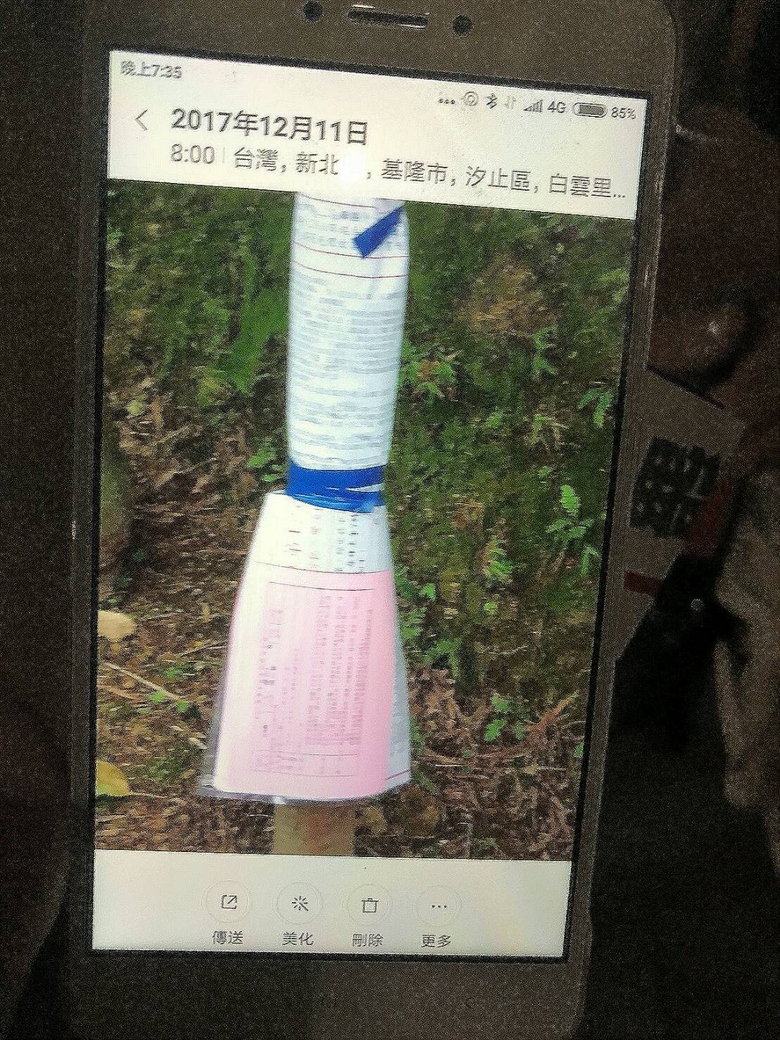 安定力量志工向民眾翻拍12月11日拍到投票通知單綁在電線桿的手機照片。 （安定力量提供）