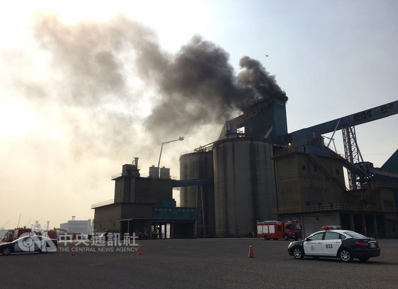 高雄港73號碼頭一處40米高的廢棄倉庫，21日疑因現場拆除工程施工不慎引發火警，現場黑煙密布直衝雲霄。 圖 : 中央社