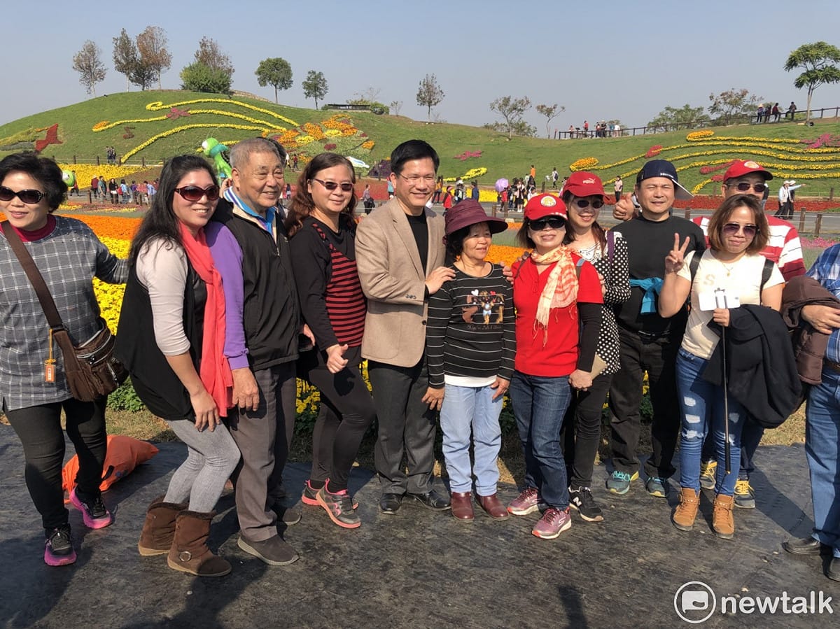 參加花毯節的遊客紛紛搶著與台中市長林佳龍合照，，讓他幾乎成了會場的人形立牌。 圖：王鵬宇/攝