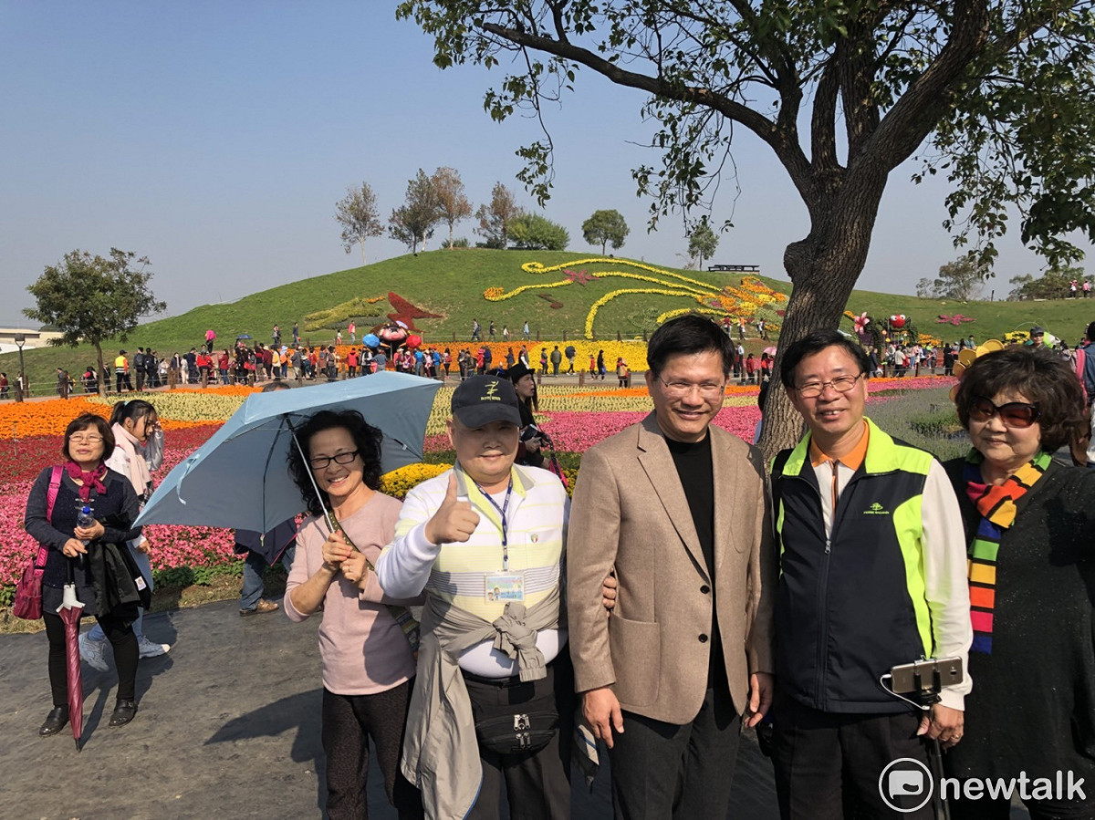 參加花毯節的遊客紛紛搶著與林佳龍合照。 圖：王鵬宇/攝