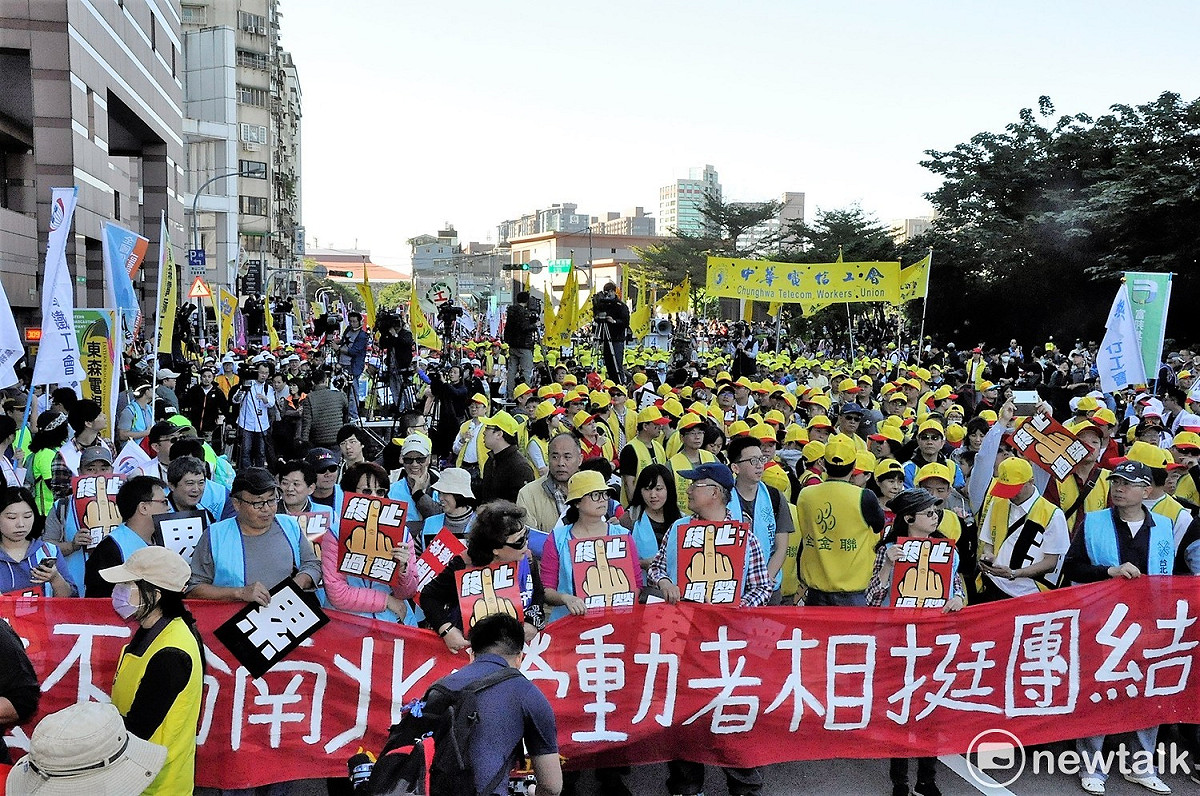 民眾手拿標語參加遊行。 圖：陳香蘭/攝
