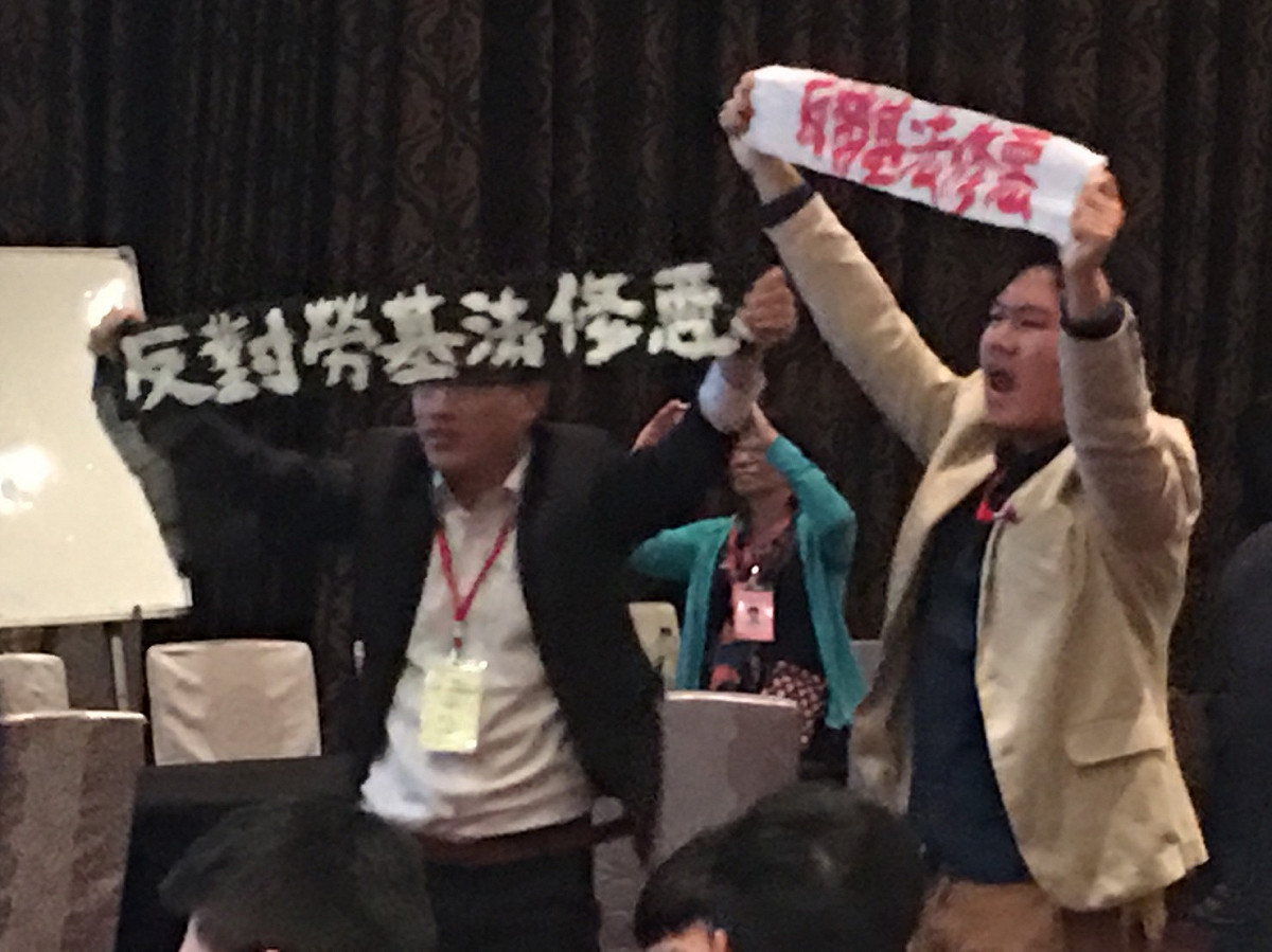 賴清德在「台灣88工商協進會」大會現場，遭勞團成員舉布條嗆聲抗議。 圖：張正霖/攝