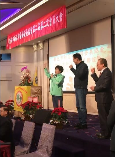 民進黨市議員廖筱清(左一)主動帶領「新店中醫藥協會」會員們，高喊「周錫瑋！凍蒜！」周錫瑋趕緊從下台跑上台，跟著呼喊。 圖：王峻昌翻攝
