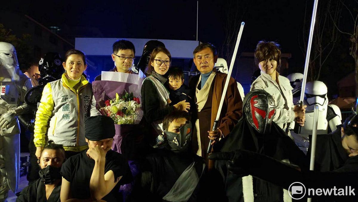 李俊毅跨年夜在台南市海安商圈舉辦愛心園遊會，扮演絕地武士，手持光劍，陪台南市民一起跨年，其妻王麗情也帶著小孫子獻花給阿公。 圖：黃博郎／攝