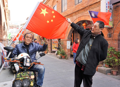 金門模範街上1日出現中華民國國旗和中國大陸五星旗同步飄揚的景觀，發想者王明宗（左）說，當成裝置藝術，吸引人潮打卡拍照；東門里長蔡祥坤（右）說，可以促進商機。 圖 : 中央社