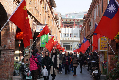 日是中華民國107年元旦，金門模範街上青天白日滿地紅國旗和中國大陸五星旗同步飄揚，有民眾和遊客爭相拍照打卡，但也有人認為怪怪的。 圖 : 中央社
