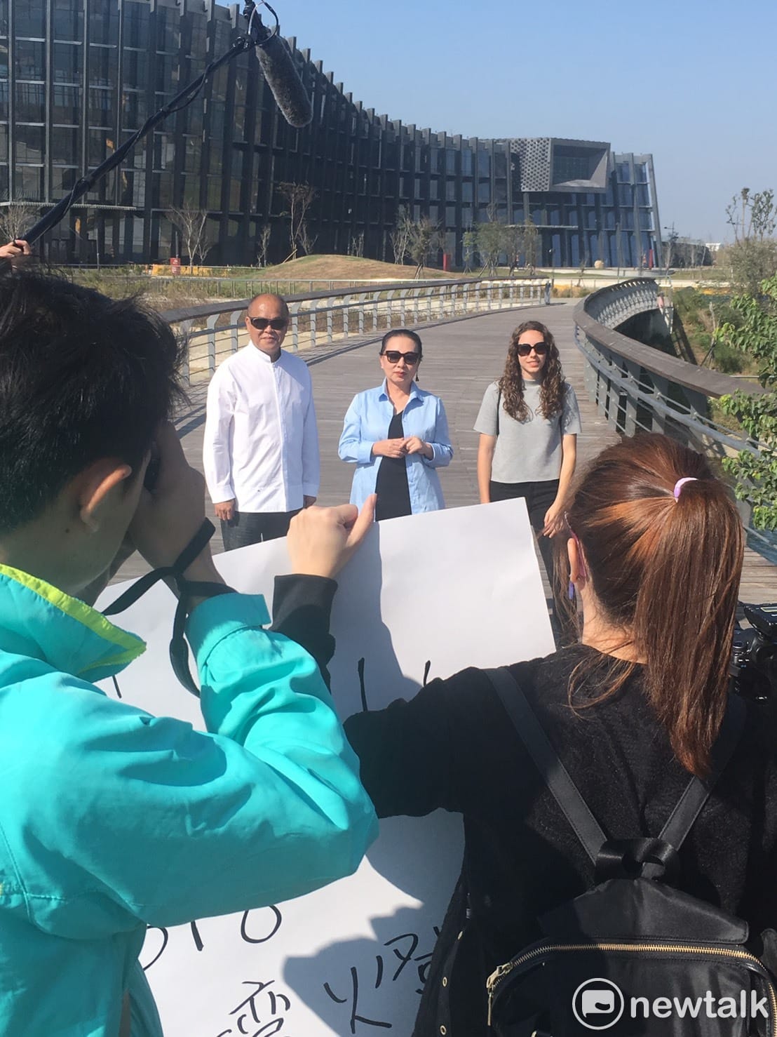 為行銷台灣燈會，嘉義縣長張花冠、議長張明達和外國朋友一起擔綱，在大太陽下，於故宮南院拍攝廣告影片。 張正霖/攝影
