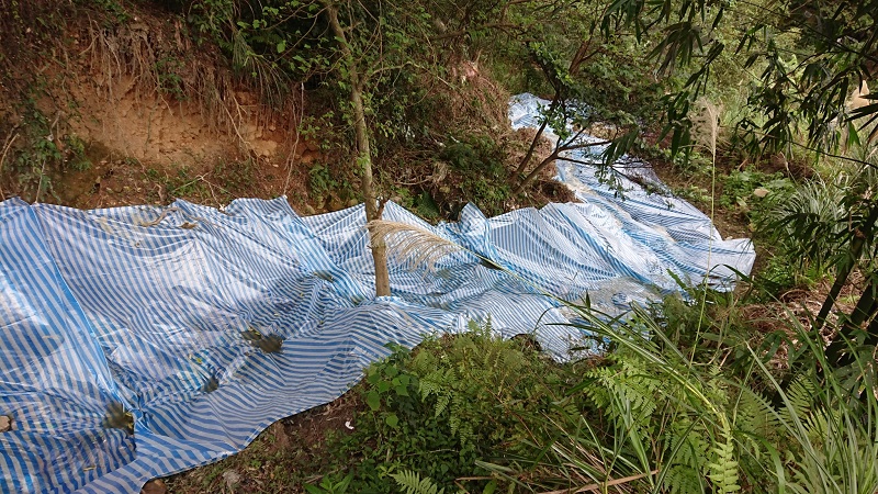 汙水隨著鋪帆布的蝕溝排入新北市十八份坑溪上游。 圖：翻攝新北市環保局網站