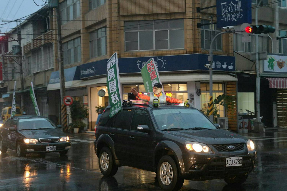 李俊毅在新化、新市、善化地區進行車隊遊行，一路頂著寒風冷雨向民眾揮手致意，獲得不少民眾熱情回應。 圖：黃博郎／攝