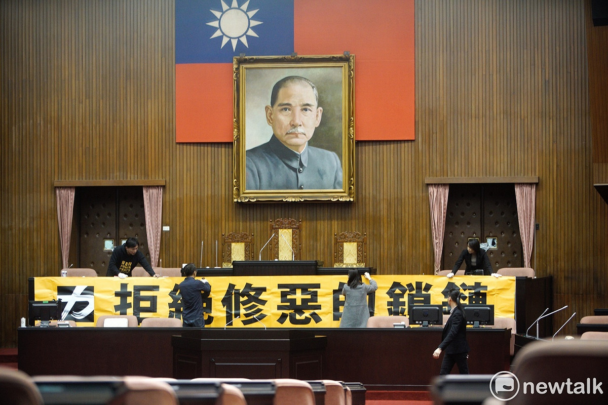 時力立委們將標語掛上主席台。 圖：張良一/攝