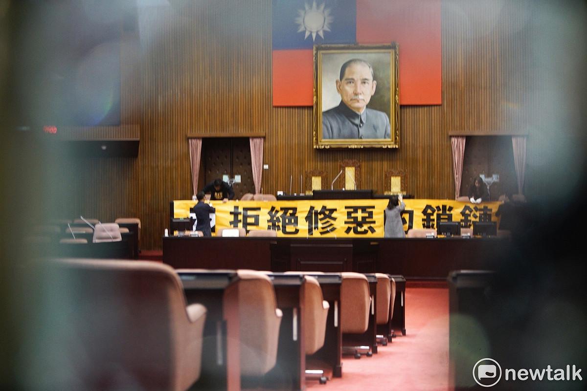 從門縫中看見議場內時力立委的一舉一動。 圖：張良一/攝