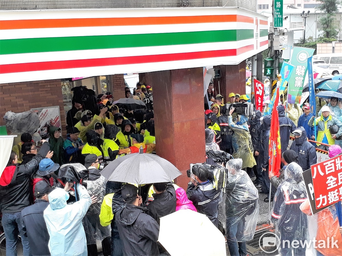 勞團今天從林森南路轉青島東路時，路過小七， 遭警方阻擋；雙方在便利店廊道發生第二次衝突。 圖:陳香蘭／攝
