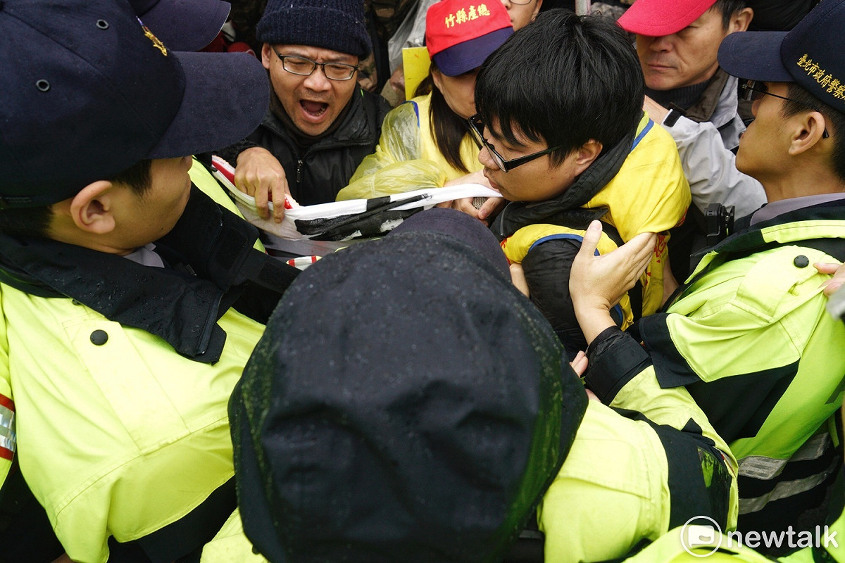 反對修改勞基法的勞工團體在凱道丟拖鞋抗議，隨即遭警方奪下尚未丟擲的拖鞋，因而爆發推擠衝突。 圖：張良一/攝