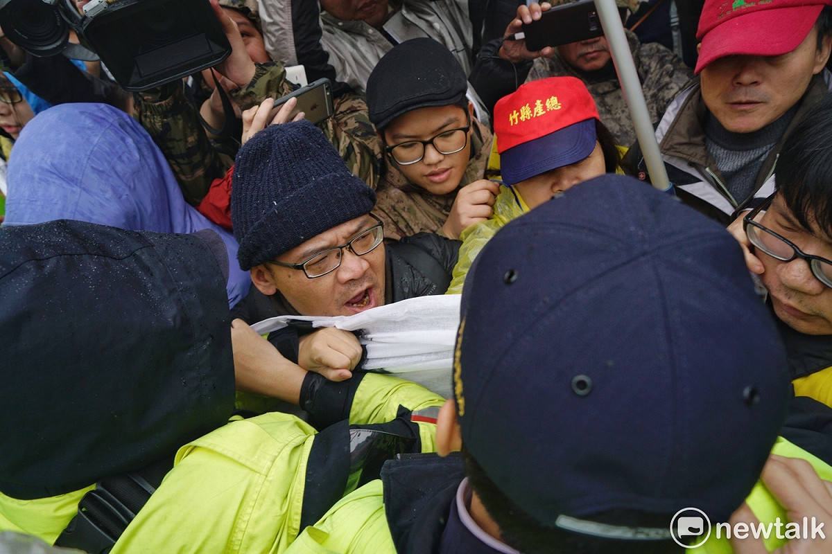 反對修改勞基法的勞工團體在凱道丟拖鞋抗議，隨即遭警方奪下尚未丟擲的拖鞋，因而爆發推擠衝突。 圖：張良一/攝