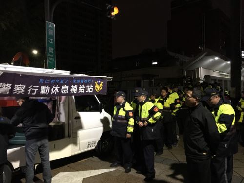 勞基法修正案挑燈夜戰，因應場外勞團抗議，警政署也加派警力支援，晚間10時多，「警察行動休息補給站」也開進立法院後門的鎮江街上，提供執勤員警宵夜適時補充能量，吸引大批員警排隊領取。 圖：中央社