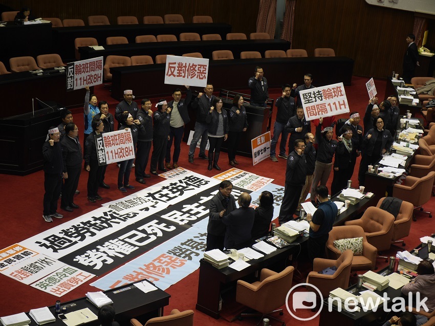 立法院二讀通過「輪班間隔休息時間調降」時，國民黨立委一擁而上，聚集於主席台前高喊「反對輪班間隔11小時改8小時」、「反對勞基法修惡」。 圖：趙婉淳／攝