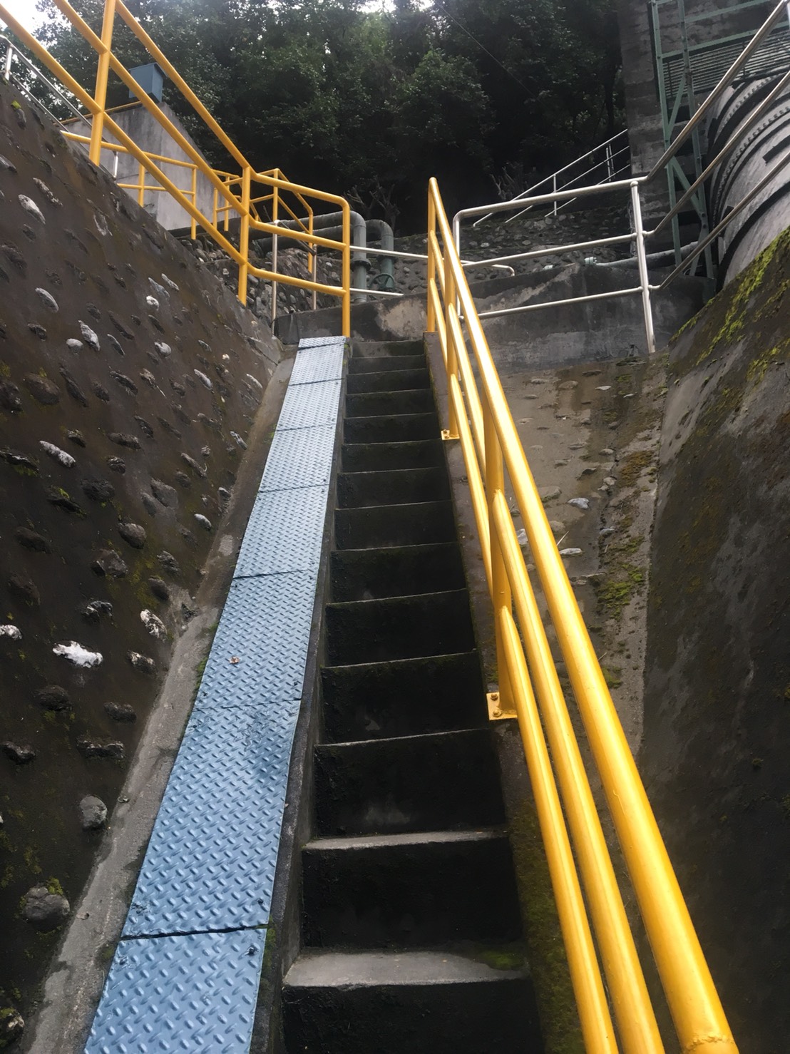 台電建置微水力機組的人員，得扛著管線走上狹窄鐵樓梯。 圖：台電提供