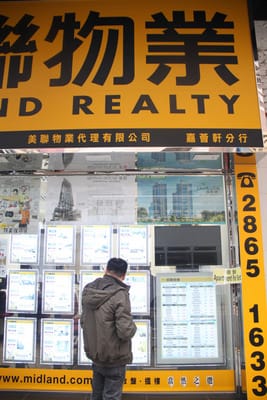 香港房價高昂，港島灣仔一間只有300多平方英尺的住房，售價動輒要600萬元以上（新台幣2340萬元），許多人不能負擔，只租得起板間房。圖為灣仔一家房屋代理商，民眾正在查找住房資訊。 圖 : 中央社