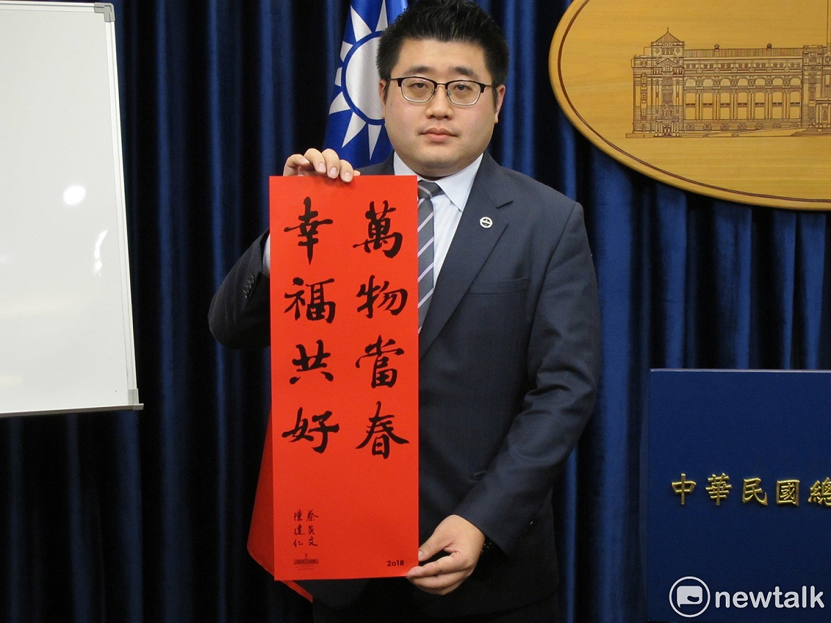 總統府發言人林鶴明22日手持2018總統府春聯。、 圖：林朝億/攝