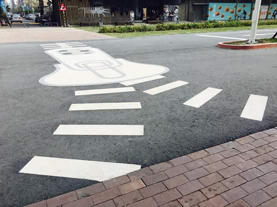 高雄駁二藝術特區的「駁遊路」，布設擬真路燈、路牌、魚骨頭斑馬線、水管噴水花的標線及各式各樣有趣的號誌牌超有哏，翻轉一般人對馬路的印象。 圖：高雄文化局/提供