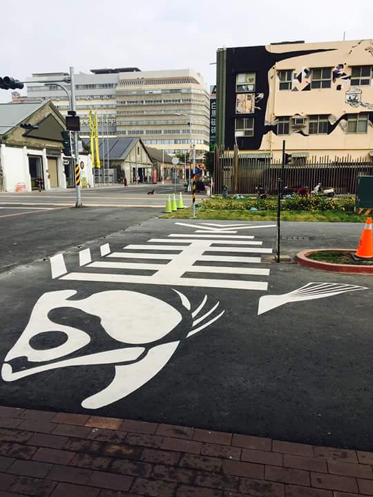 高雄駁二藝術特區的「駁遊路」，布設擬真路燈、路牌、魚骨頭斑馬線、水管噴水花的標線及各式各樣有趣的號誌牌超有哏，翻轉一般人對馬路的印象。 圖：高雄文化局/提供