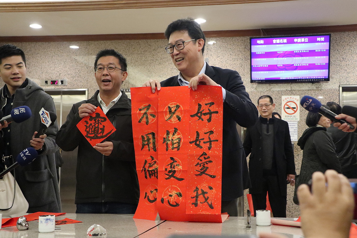 民進黨主席、總統蔡英文昨在尾牙特別點名有意參選台北市長的立委姚文智，並稱「若我有偏心，也是偏你」，姚文智今日揮毫寫春聯回應小英「好好愛我」。 圖：姚文智辦公室 / 提供