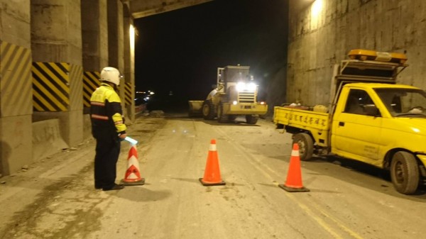 地震後蘇花公路164公里附近發生落石，花蓮縣新城警分局派出和平所警員在場管制通行。 圖：花蓮縣新城警分局提供