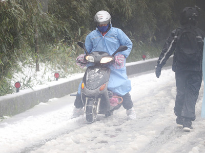 民眾上山賞雪，機車掛雪鏈仍寸步難行。 圖：中央社