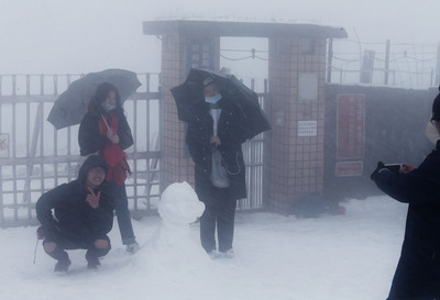 民眾上大屯山助航站賞雪合影。
 圖：中央社