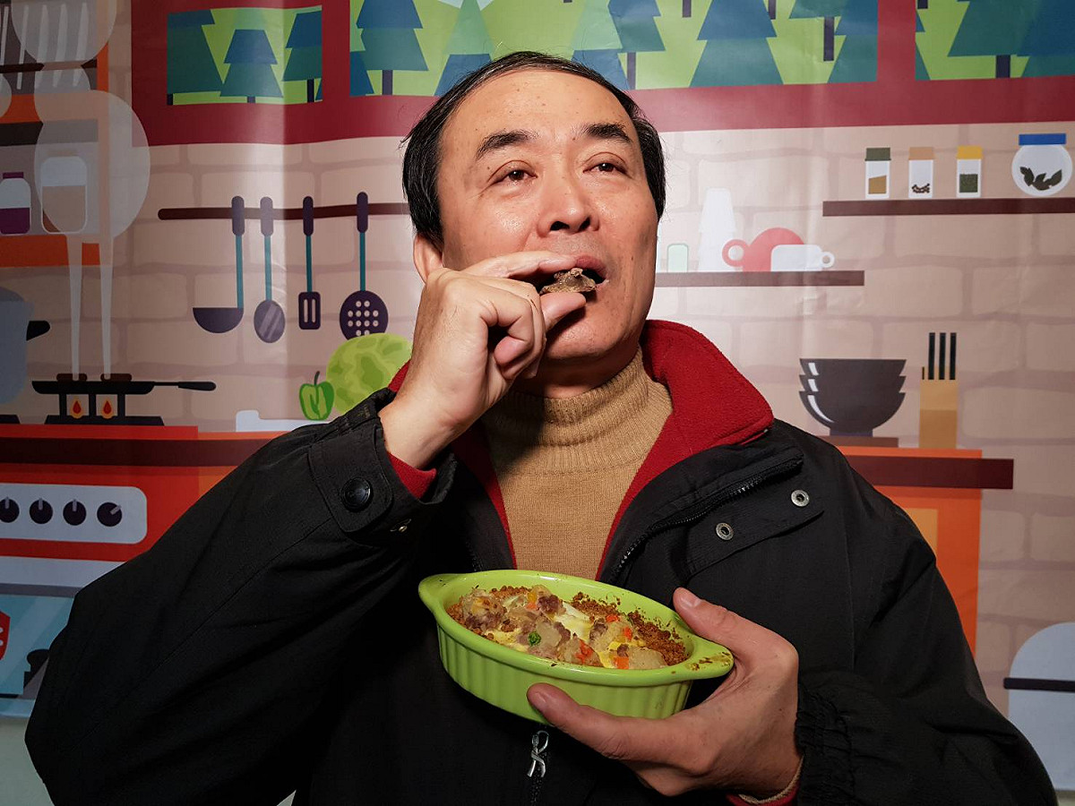 新北動保處準備的毛寶精緻年菜，可供毛爸媽們一起共享；圖為動保處長陳淵泉示範享用毛寶貝年菜。 圖：王峻昌/攝