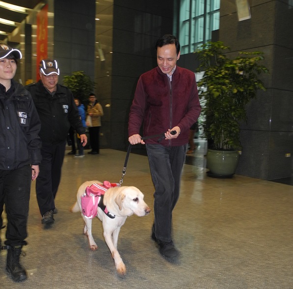 朱立倫牽著警犬亮相發送福袋，與民眾提前迎接狗年旺來。 圖：王峻昌/攝