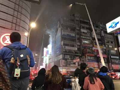 台北市東區百貨旁大樓10日晚間傳出火警，警消到場灌救，周邊民眾關注。 圖:中央社