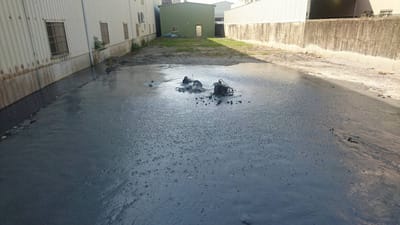 高雄市鳥松區興農巷一處鐵皮工廠旁路面14日上午噴發泥漿，波及鄰近道路，警消獲報到場拉起封鎖線，並協同環保局、農業局及鳥松區公所等單位輪番派員到場警戒，所幸噴漿量不大，未釀成災。 高市環保局提供
