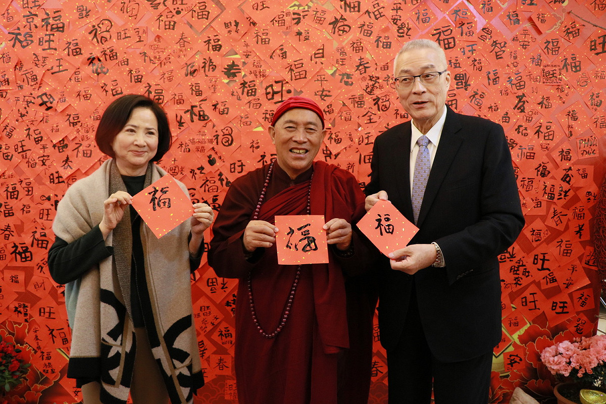 吳敦義、蔡令怡夫婦與靈鷲山開山住持心道法師一起用毛筆寫下「福」字，貼在千福牆上，為花蓮地震災民祈福。 圖：靈鷲山聖山寺/提供