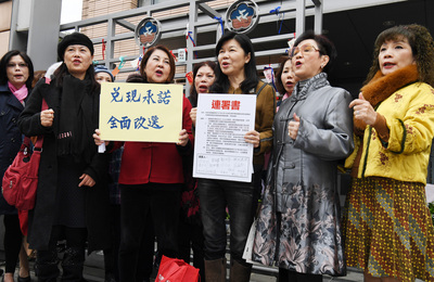 前婦聯會常委潘維剛（中）要求婦聯會主委雷倩召開會
員代表大會並全面改選常委，26日前往婦聯會遞交連署
書，在大門外呼口號。 圖：中央社